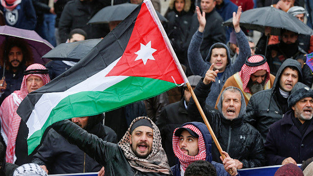 Protesters hold the Jordanian flag and shout slogans during a protest against U.S. President Donald Trump's proposed Middle East peace plan, near the U.S. Embassy in Amman, Jordan, February 7, 2020.