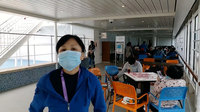 Passengers wear protective masks aboard the World Dream cruise ship, being quarantined at Kai Tak Cruise Terminal amid concerns of coronavirus infections, in Hong Kong, China February 8, 2020 in this still image obtained from social media