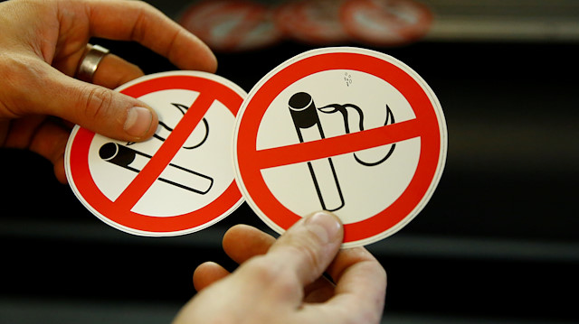 An employee shows no smoking signs in the Karas printing shop in Vienna, Austria