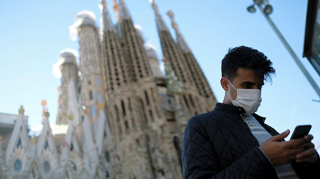 A man wears a protective mask in front of Basilica Sagrada Familia