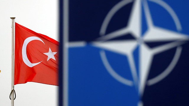  Turkish flag flies next to NATO logo at the Alliance headquarters in Brussels