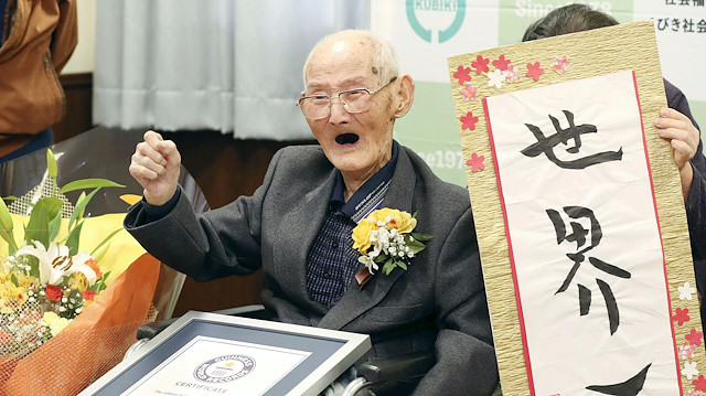 112-year-old Chitetsu Watanabe poses next to the calligraphy reading 'World's Number One' after being awarded as the world's oldest living male by Guinness World Records, in Joetsu, Niigata prefecture, northern Japan February 12, 2020.