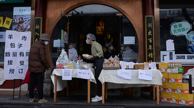 File photo: A customer wearing a face mask buys vegetables from a stall set up by a hotpot restaurant outside its outlet in central Beijing, following an outbreak of the novel coronavirus in China, February 13, 2020