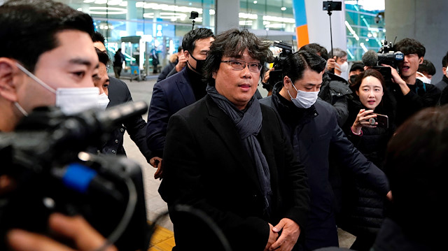 Director of four Oscar award-winning film 'Parasite' Bong Joon-ho is escorted by security personnel as he leaves Incheon International Airport, South Korea, February 16, 2020. REUTERS/Kim Hong-Ji  