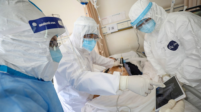 Wuhan'daki Kızılhaç Hastanesi'nin izole bir koğuşundaki bir hasta muayene ediliyor.