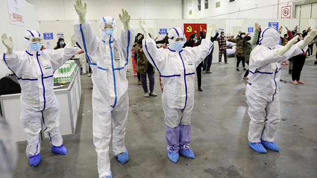 Medical workers in protective suits dance with patients inside the Wuhan Parlor Convention Center that has been converted into a makeshift hospital following an outbreak of the novel coronavirus, in Wuhan, Hubei province, China February 15, 2020. Picture taken February 15, 2020. China Daily via REUTERS ATTENTION EDITORS - THIS IMAGE WAS PROVIDED BY A THIRD PARTY. CHINA OUT.

