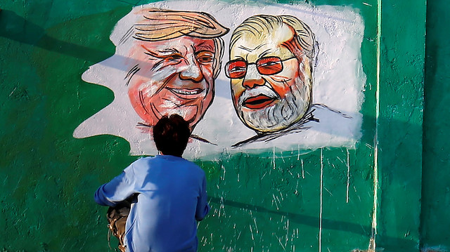 A man applies finishing touches to paintings of U.S. President Donald Trump and India's Prime Minister Narendra Modi on a wall as part of a beautification along a route that Trump and Modi will be taking during Trump's upcoming visit, in Ahmedabad, India, February 17, 2020. REUTERS/Amit Dave

