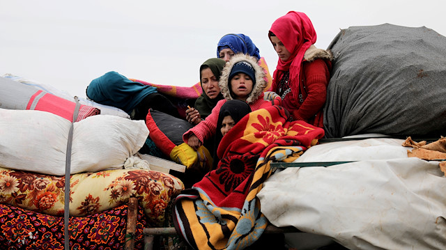 File photo: Internally displaced Syrians from western Aleppo countryside, ride on a vehicle with belongings in Hazano near Idlib, Syria, February 11, 2020