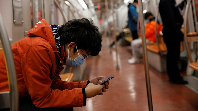 File photo: A man wearing a face mask checks his mobile phone while riding a subway in the morning after the extended Lunar New Year holiday caused by the novel coronavirus outbreak, in Beijing, China February 10, 2020