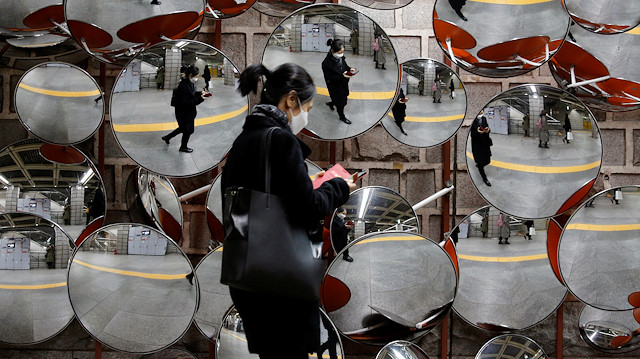 File photo: A woman wearing a mask to prevent the coronavirus is reflected in the mirrors, in Seoul, South Korea, February 24, 2020