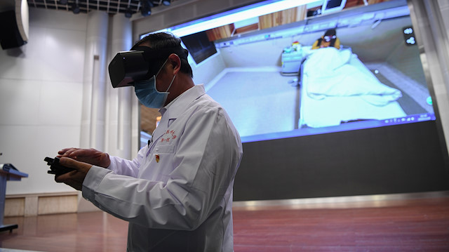 File pohoto: A medical staff wearing a virtual reality (VR) goggles checks a patient remotely at a hospital, following an outbreak of the novel coronavirus in the country, in Kunming, Yunnan province, China February 24, 2020.