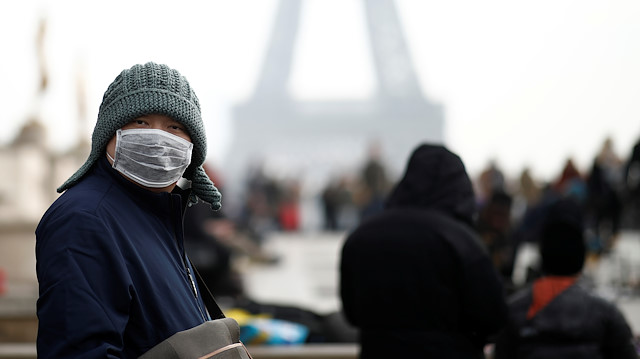 Bir adam, 25 Ocak 2020'de Paris, Fransa'daki Eyfel Kulesi'nin önünde yüz maskesi takıyor, çünkü Fransa salgının ülkeye geldiğini doğruladı.