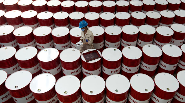 A worker prepares to label barrels of lubricant oil at the state oil company