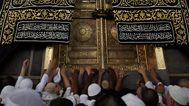 Muslims touch and pray at the door of the Kaaba and touch and kiss the al-Hajr al-Aswad