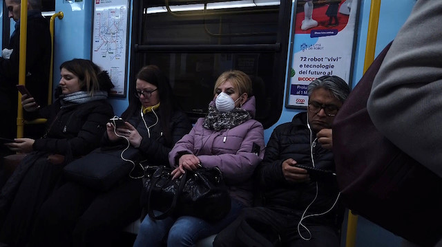 A woman wearing a protective mask takes the metro during rush hour in Milan, Italy