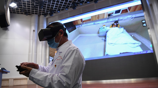 File photo: A medical staff wearing a virtual reality (VR) goggles checks a patient remotely at a hospital, following an outbreak of the novel coronavirus in the country, in Kunming, Yunnan province, China February 24, 2020