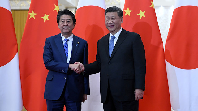 Japan's Prime Minister Shinzo Abe shakes hands with China's President Xi Jinping 
