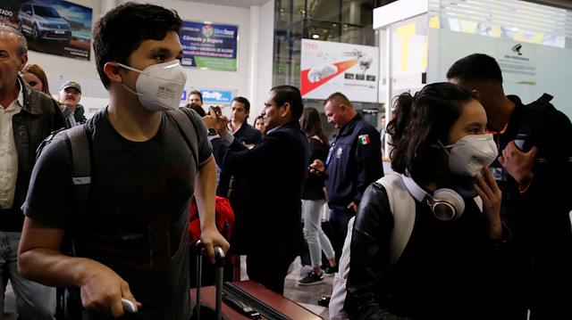 Mexican students wear protective masks upon their arrival