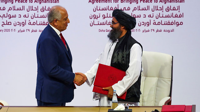 FILE PHOTO: Mullah Abdul Ghani Baradar, the leader of the Taliban delegation, and Zalmay Khalilzad, U.S. envoy for peace in Afghanistan, shake hands after signing an agreement at a ceremony between members of Afghanistan's Taliban and the U.S. in Doha, Qatar, February 29, 2020