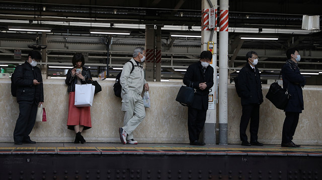 Koronavirüsün patlak vermesinin ardından koruyucu yüz maskeleri takan insanlar, Japonya'daki Tokyo istasyonunda trenlerini bekliyorlar. 