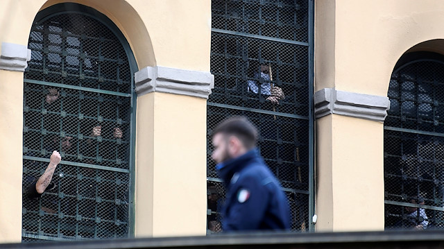 Prison inmates gather by a barred window at San Vittore Prison as part of a revolt after family visits were suspended due to fears over coronavirus contagion, in Milan, Italy March 9, 2020.