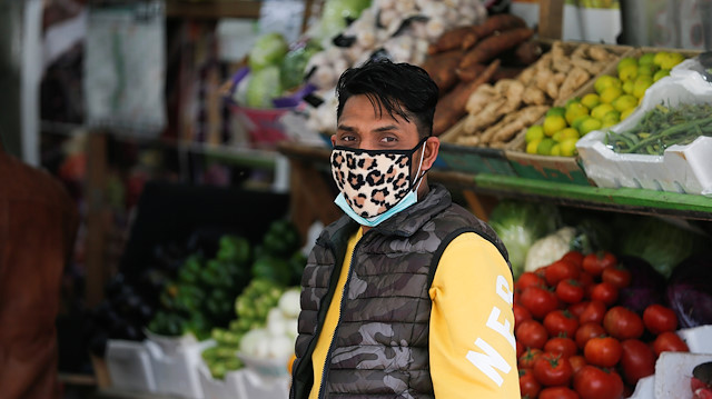A vendor wears a protective face mask following the coronavirus outbreak, at a local vegetables and fruits market in Sanabis west of Manama, Bahrain February 27, 2020. 