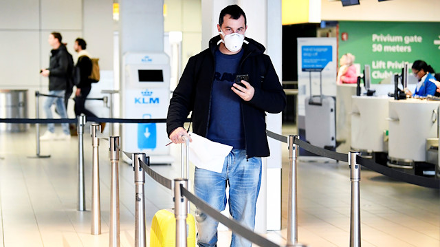 File photo:A traveler wears a mask in the departure hall at the KLM Service Desk, as the travel ban for European countries announced by U.S. President Donald Trump has major consequences for the world of travel and travelers that have just arrived from U.S., in Schiphol, Netherlands March 12, 2020