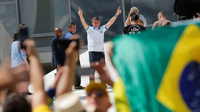 Brazil's President Jair Bolsonaro gestures as he greets his supporters during a protest against Brazil's Congress and Brazilian Supreme Court in front the Planalto Palace in Brasilia, Brazil March 15, 2020