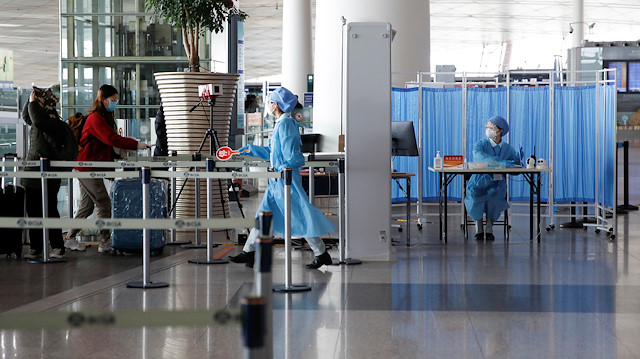 File photo: Staff members wearing protective gear check passengers entering Beijing Capital International Airport as the country is hit by an outbreak of the novel coronavirus, in Beijing, China March 16, 2020