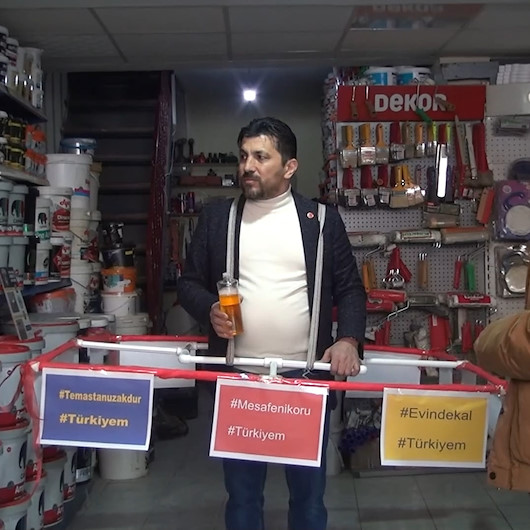 Koronavirüsten korunmak için 1 buçuk metrelik su borusu ile dolaşıyor