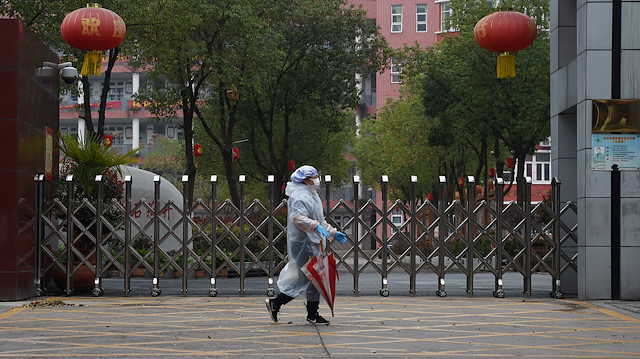 File photo: A resident in protective gear walks past the entrance of a closed secondary school in Wuhan, the epicentre of the novel coronavirus outbreak, Hubei province, China March 9, 2020
