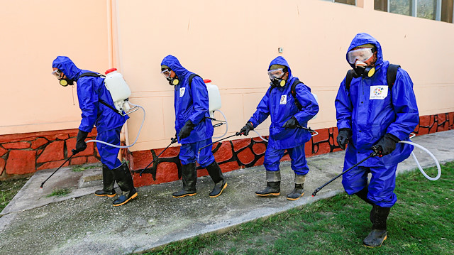 File photo: Health workers wearing protective suits spray disinfectant outside of a building during an awareness campaign for coronavirus disease (COVID-19), in Jalalabad, Afghanistan March 19, 2020