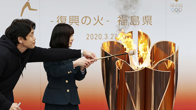 A junior highschool student lights the Olympic flame at an Olympic cauldron during the Tokyo 2020 Olympics Flame of Recovery tour in Fukushima, Japan March 24, 2020, in this photo taken by Kyodo. Mandatory credit Kyodo via REUTERS ATTENTION EDITORS - THIS IMAGE WAS PROVIDED BY A THIRD PARTY. MANDATORY CREDIT. JAPAN OUT. NO COMMERCIAL OR EDITORIAL SALES IN JAPAN.  