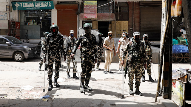 Paramilitary personnel and police officers stand guard on the street as India ordered a 21-day nationwide lockdown to limit the spreading of coronavirus disease (COVID-19), in New Delhi, India, March 25, 2020. 
