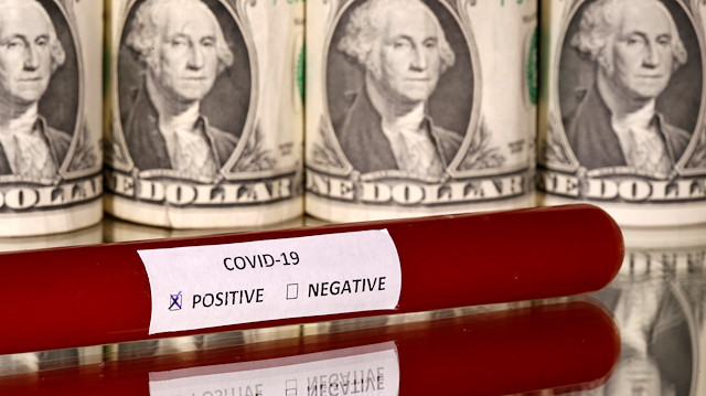 FILE PHOTO: A test tube labelled with the coronavirus is seen in front of U.S. dollar banknotes, in this illustration taken on March 1, 2020