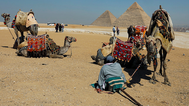 A man waits for tourists to rent his camels in front of the Great Pyramids of Giza, on the outskirts of Cairo, Egypt March 8, 2020. REUTERS/Mohamed Abd El Ghany

