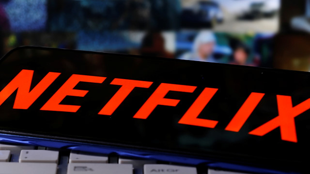 A smartphone with the Netflix logo is seen on a keyboard in front of displayed "Streaming service" words in this illustration taken March 24, 2020. REUTERS/Dado Ruvic


