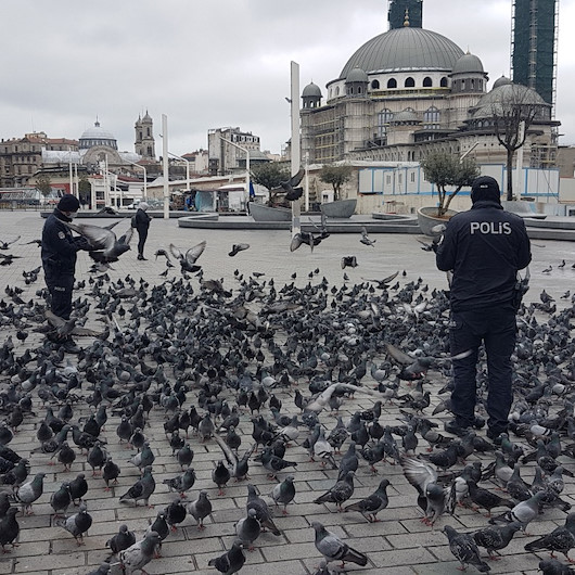 Polis memurları Taksim Meydanında aç kalan güvercinleri besledi