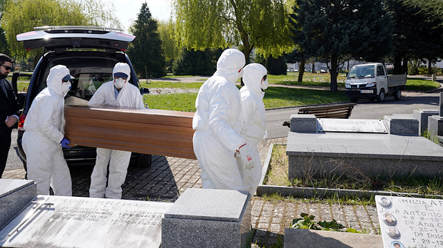 File photo: Municipal workers wearing protective gear carry the coffin of a victim of the coronavirus disease (COVID-19) at El Salvador cemetery in Vitoria, Spain, March 27, 2020