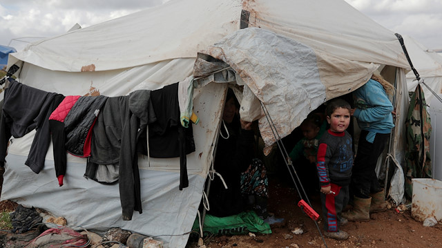  An internally displaced Syrian child from Idlib, stands outside a tent in Azaz