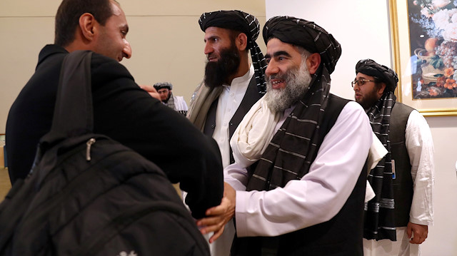 FILE PHOTO: Members of Afghanistan's Taliban delegation (R) gather ahead of an agreement signing between them and U.S. officials in Doha, Qatar, February 29, 2020. REUTERS/Ibraheem al Omari/File Photo

