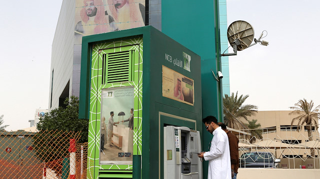 A man withdraws money from an ATM outside the Saudi National Commercial Bank (NCB), after an outbreak of coronavirus, in Riyadh, Saudi Arabia, March 18, 2020. REUTERS/Ahmed Yosri

