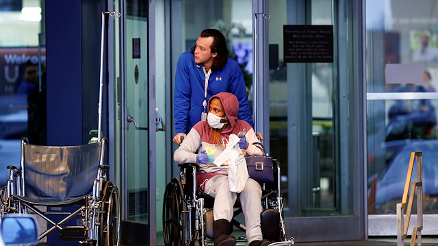 A patient exiting the University of Illinois Hospital is pushed in a wheelchair
