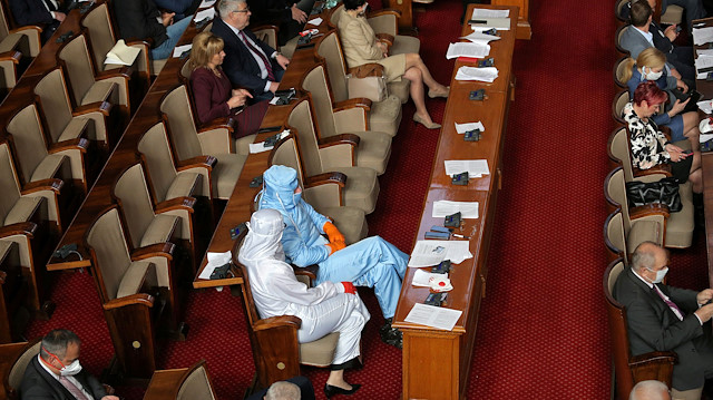 File photo: Veselin Mareshki, leader of Bulgarian party Volya (Will), and a deputy from his party wear protective suits during debates in the parliament in Sofia, Bulgaria, March 20, 2020