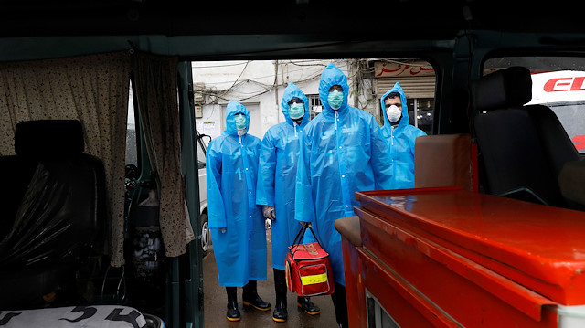 File photo: Volunteers of the Edhi Foundation, a non-profit social welfare programme, wear raincoats and boots as they pose during a mock drill on handling suspected carriers of the coronavirus disease (COVID-19), in Karachi, Pakistan March 26,2020