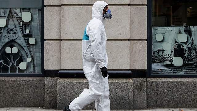 A man wears personal protective equipment (PPE) as he walks on First Avenue