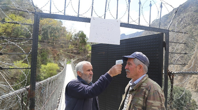 Bölge halkı, gelenlerin ateşini ölçerek içeri alıyor.