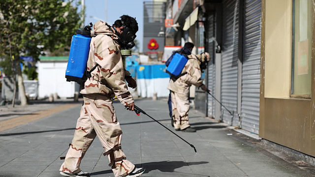 File photo: Volunteers from Basij forces wearing protective suits and face masks spray disinfectant in the streets, amid the coronavirus disease (COVID-19) fears, in Tehran