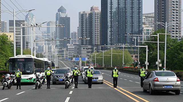 Traffic police officers and vehicle drivers observe a moment of silence on a road in Wuhan, Hubei province, as China holds a national mourning for those who died of the coronavirus disease (COVID-19), on the Qingming tomb-sweeping festival, April 4, 2020