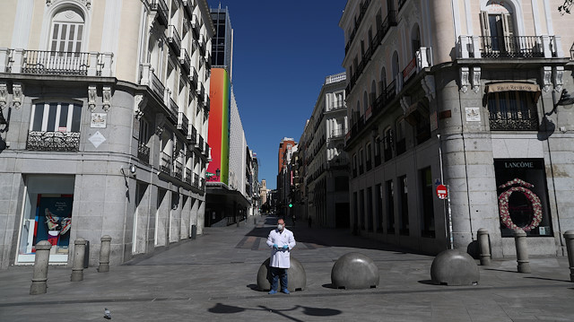 A pharmacist in protective gear stands in a deserted Puerta del Sol square, during the lockdown amid the coronavirus disease (COVID-19) outbreak, in Madrid, Spain, April 4, 2020. 